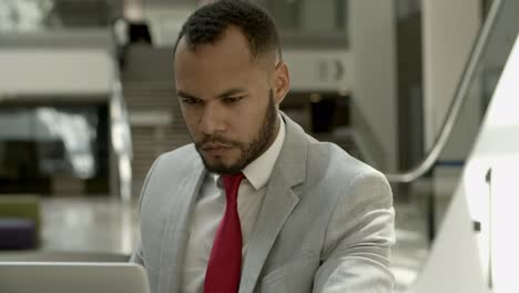 Focused-African-American-man-looking-at-laptop